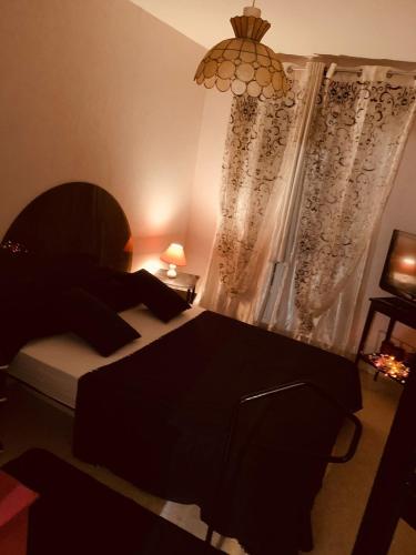 - une chambre avec un lit et une fenêtre ornée d'un lustre dans l'établissement Visa pour l image Wellcome la famille et les enfants, à Perpignan