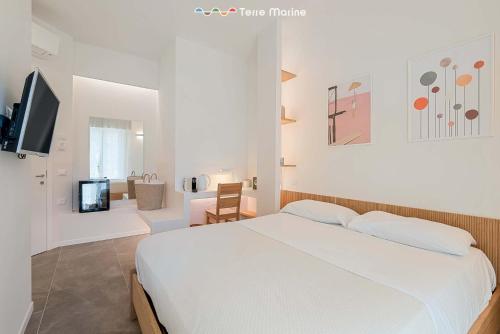 a white bedroom with a bed and a living room at Affittacamere Isabella, Terre Marine in Levanto