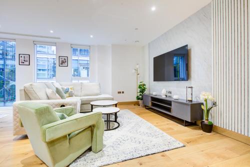 a living room with a couch and a tv at London Paddington Apartment in London
