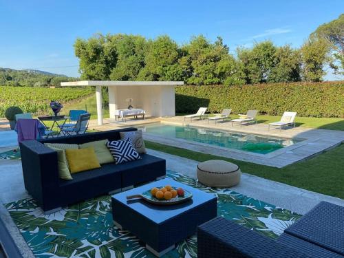 - une terrasse avec un canapé et une corbeille de fruits dans l'établissement villa au cœur des vignes, à Cogolin