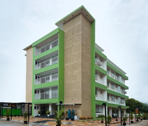un edificio de apartamentos alto, verde y blanco en Olive Residence, Near Lakeshore Hospital, en Kochi