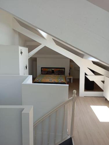 une chambre avec un lit dans une pièce blanche dans l'établissement Appartement loft 55m2 climatisé, à Courtemanche