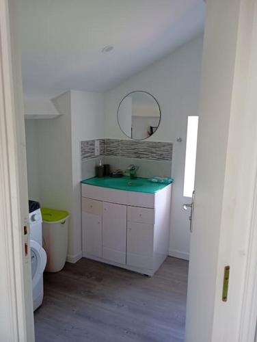 une salle de bain blanche avec un lavabo et un miroir dans l'établissement Appartement loft 55m2 climatisé, à Courtemanche