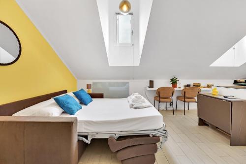 a bedroom with a bed with blue pillows and a kitchen at DUOMO - Bright Gateway Downtown in Milan