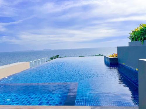 a swimming pool with the ocean in the background at Exclusive condo & Seaview in Ban Bang Saen (1)