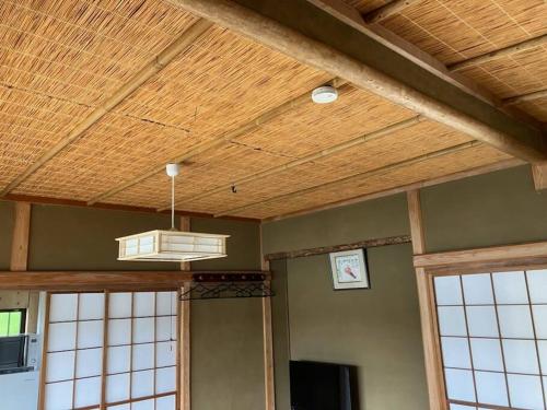 a room with a wooden ceiling with a light at やどかり志摩の隠れ家 in Shima