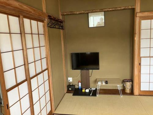 a room with a flat screen tv on the wall at やどかり志摩の隠れ家 in Shima