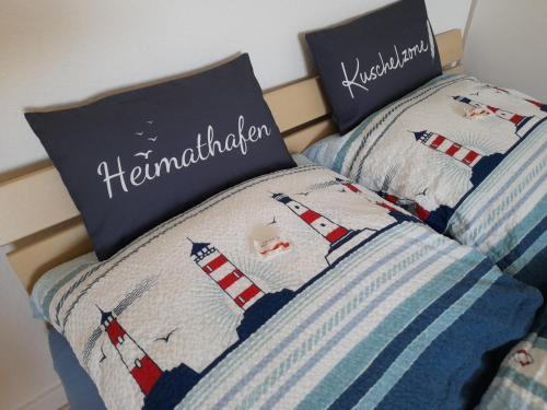 a bed with two pillows on top of it at Pension Entenhausen in Schwentinental