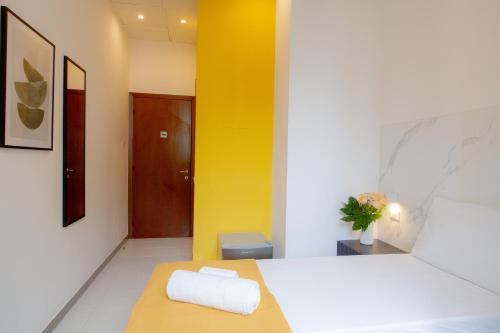 a room with a bed and a yellow wall at RRRapido Hotel in Sesto San Giovanni