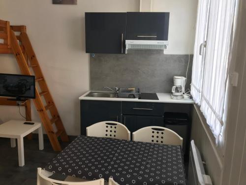 une cuisine avec une table, des chaises et un évier dans l'établissement Studio 2 proche mer Dunkerque Malo les bains, à Dunkerque