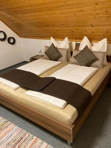 duże łóżko z białą pościelą i poduszkami w obiekcie Ferienwohnung Steinwender w mieście Döbriach