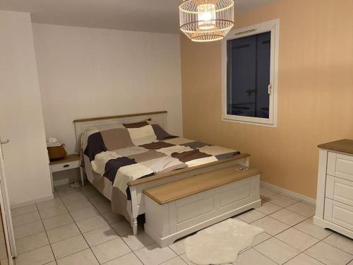 une chambre avec un lit, une fenêtre et un lustre dans l'établissement Jolie maison provençale au volets bleu, à Marseille