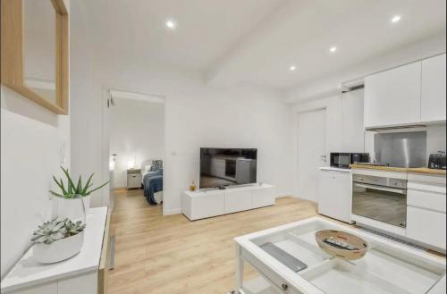 Il comprend un salon blanc avec une table et une cuisine. dans l'établissement Suquet Perrissol, à Cannes