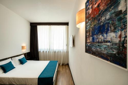 a bedroom with a bed and a painting on the wall at Hotel Cristallo in Rimini