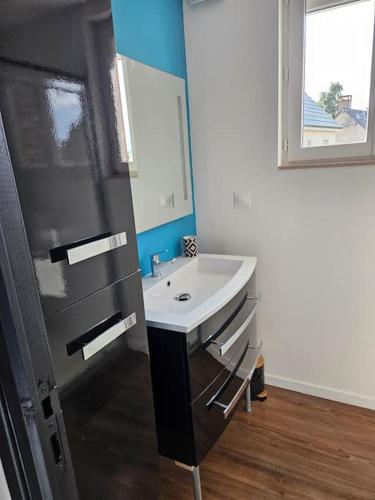 une salle de bain avec un lavabo et un miroir dans l'établissement Les Gîtes de Tourville, à Tourville-les-Ifs