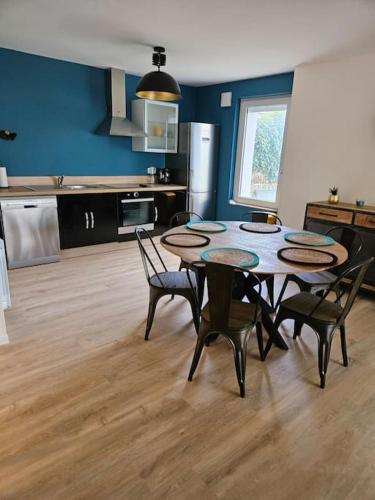 une cuisine avec une table et des chaises dans une pièce dans l'établissement Les Gîtes de Tourville, à Tourville-les-Ifs