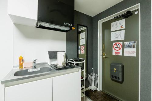 a small kitchen with a sink and a door at Super close to Dotonbori! Great location room#403 in Osaka