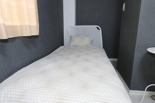 a white bed in a small room with a window at Super close to Dotonbori! Great location room#403 in Osaka