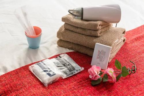 a pile of towels with a hair dryer on a table at Super close to Dotonbori! Great location room#403 in Osaka