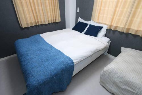 a bedroom with a bed with a blue blanket on it at Super close to Dotonbori! Great location room#403 in Osaka