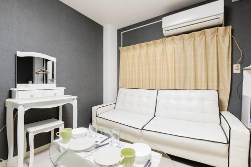 a living room with a white couch and a mirror at Super close to Dotonbori! Great location room#403 in Osaka