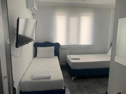 a small room with two beds and a tv at centre reach otel in Edirne