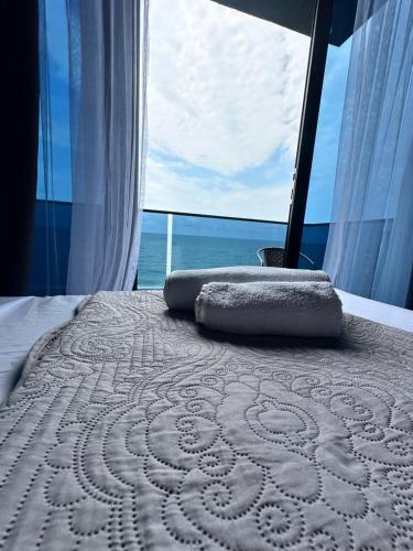 a bed with two pillows on it in front of a window at Hotel black sea in K'obulet'i