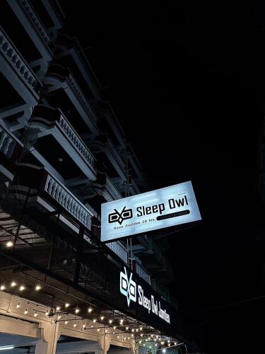 a sign hanging from the ceiling of a building at Sleep Owl Jomtien in Jomtien Beach