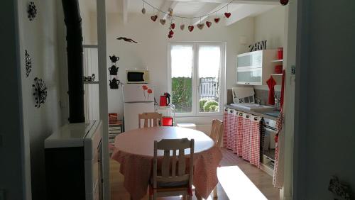 une cuisine avec une table et une cuisine avec une fenêtre dans l'établissement Diskouiz Bihan Petit Repos, à Carantec