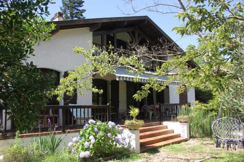 une maison avec une terrasse couverte et des escaliers. dans l'établissement Yacumama Guesthouse, à Soorts-Hossegor