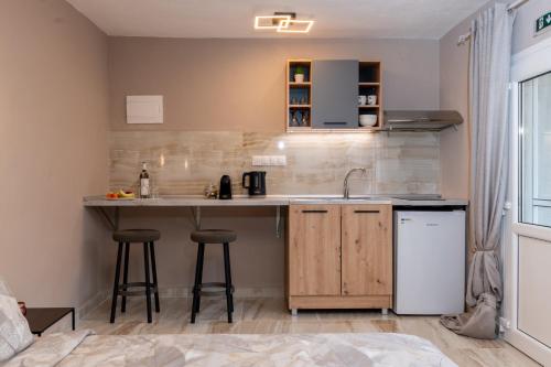 a kitchen with a sink and a counter with stools at Avli Home in Neos Marmaras