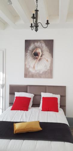 a bedroom with a bed with red pillows and a painting at Cosy 4 minutes à pieds du centre historique avec parking in Montluçon