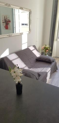 a bedroom with a bed and a vase with a plant at Cosy 4 minutes à pieds du centre historique avec parking in Montluçon
