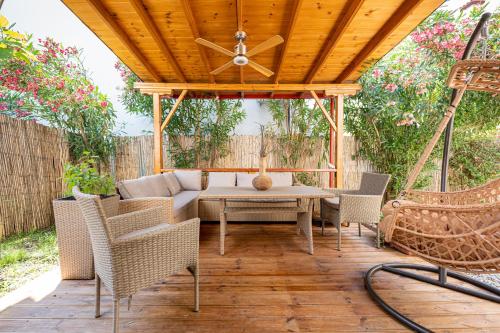 a patio with a table and chairs and a wooden ceiling at Casa Mameli Αpartments in Kallithea Halkidikis