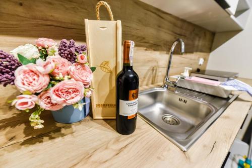 una botella de vino sentada en un mostrador junto a un fregadero en Skorzęcin Pachnie Miętą, en Skorzęcin