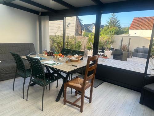 d'une table à manger et de chaises avec vue sur le patio. dans l'établissement Villa les Buissonets, à Berck-sur-Mer