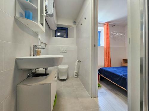 un piccolo bagno con lavandino e letto di Blu Violati a Novigrad Istria