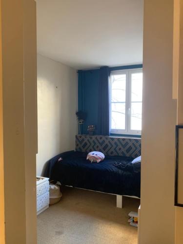 une chambre avec un lit et une fenêtre dans l'établissement Appartement cosy à 5 min de Paris, à Neuilly-sur-Seine