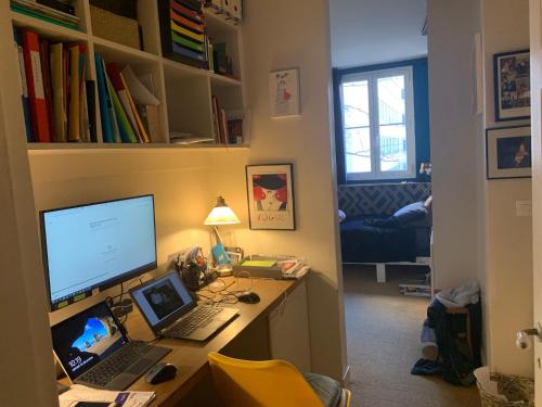 - un bureau avec un ordinateur et un ordinateur portable dans l'établissement Appartement cosy à 5 min de Paris, à Neuilly-sur-Seine