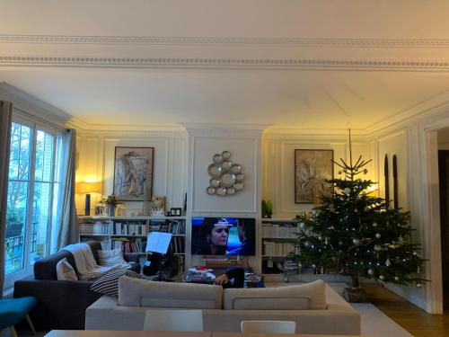 - un salon avec un arbre de Noël et un canapé dans l'établissement Appartement cosy à 5 min de Paris, à Neuilly-sur-Seine