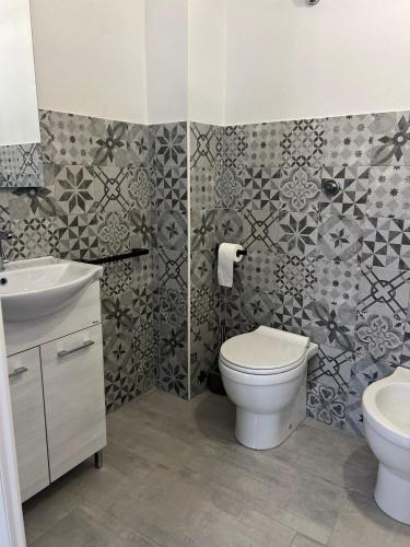 a bathroom with a toilet and a sink at Civico 9 in Bonorva