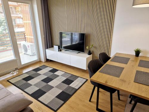 a living room with a television and a dining room table at Apartmaji PANONIA "The Modern Space" in Moravske Toplice