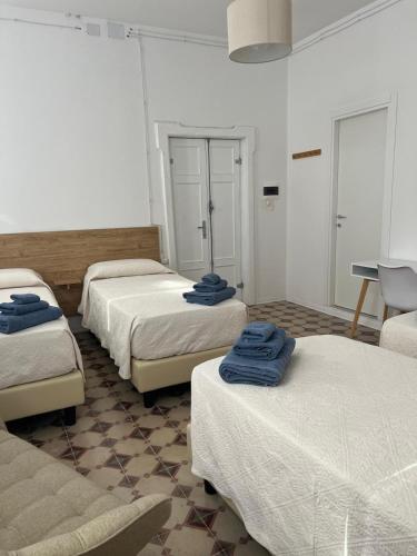 a room with four beds with blue towels on them at Civico 9 in Bonorva