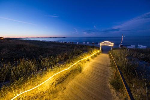 a pathway with lights on the beach at night at Aquamaris Strandresidenz Rügen in Juliusruh