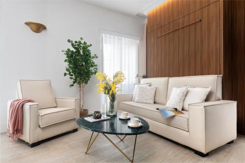 a living room with two chairs and a couch and a table at Apartamentos Sevilla Centro in Seville