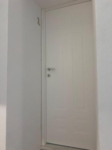 a white door with a silver handle in a room at Civico 9 in Bonorva