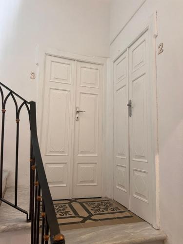 a hallway with white walls and a door and stairs at Civico 9 in Bonorva