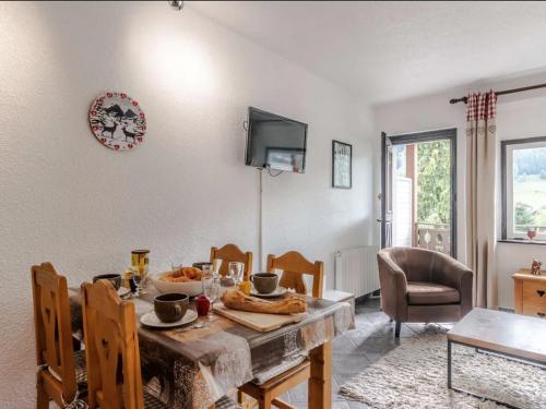 une salle à manger avec une table et une télévision dans l'établissement Charmant T2 rénové avec jardin, parking privé et accès direct aux pistes, proche du centre de Morzine - FR-1-679-12, à Morzine