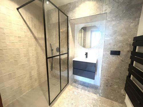 une salle de bain avec un lavabo et une douche en verre dans l'établissement Beaumont republique, à Nice