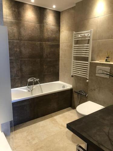 une salle de bain avec une baignoire, des toilettes et un lavabo dans l'établissement Luxury Apartment 4 w Pool, Sea and Mountain Views, à Mandelieu-la-Napoule